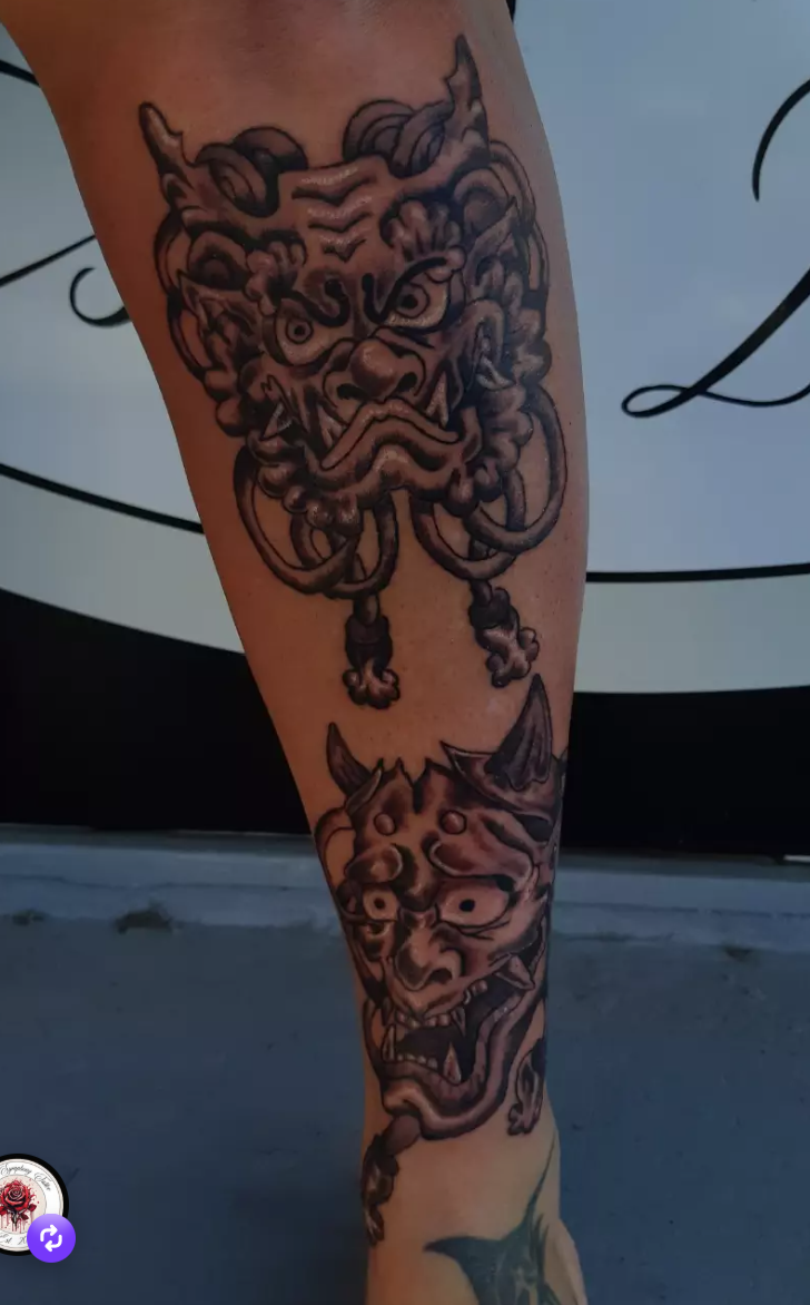 Bold traditional Japanese foo dog and hannya mask tattoo running down the calf.