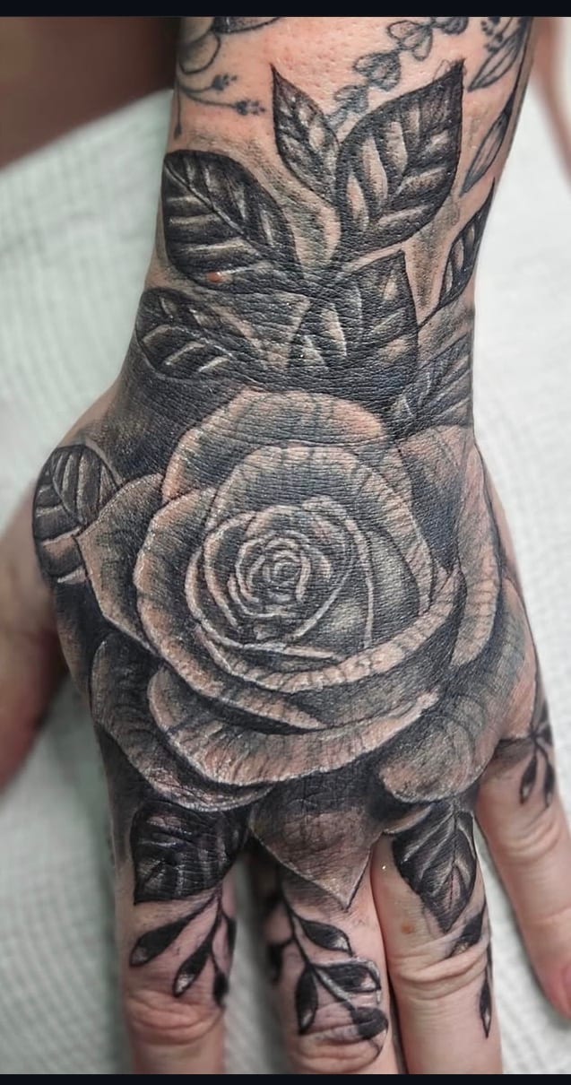 Finished black and grey rose hand cover-up tattoo by Tracey at Sweet Symphony Tattoo