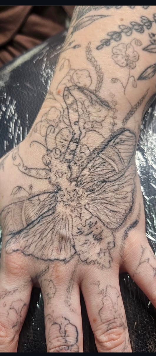 Faded linework hand tattoo before a cover-up by Tracey at Sweet Symphony Tattoo