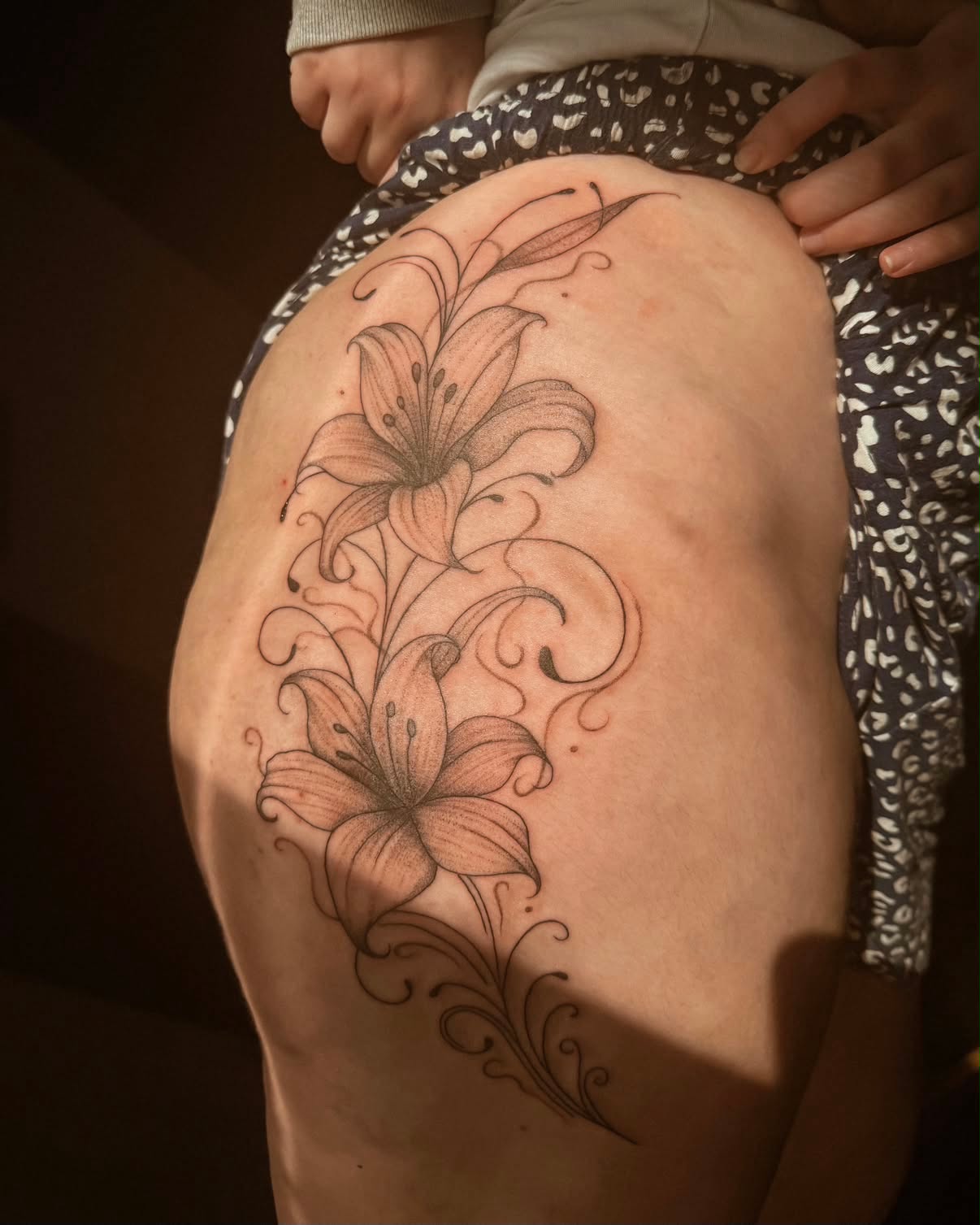 Minimalist single-line lily flowers with a vertical roman numeral date down the spine.