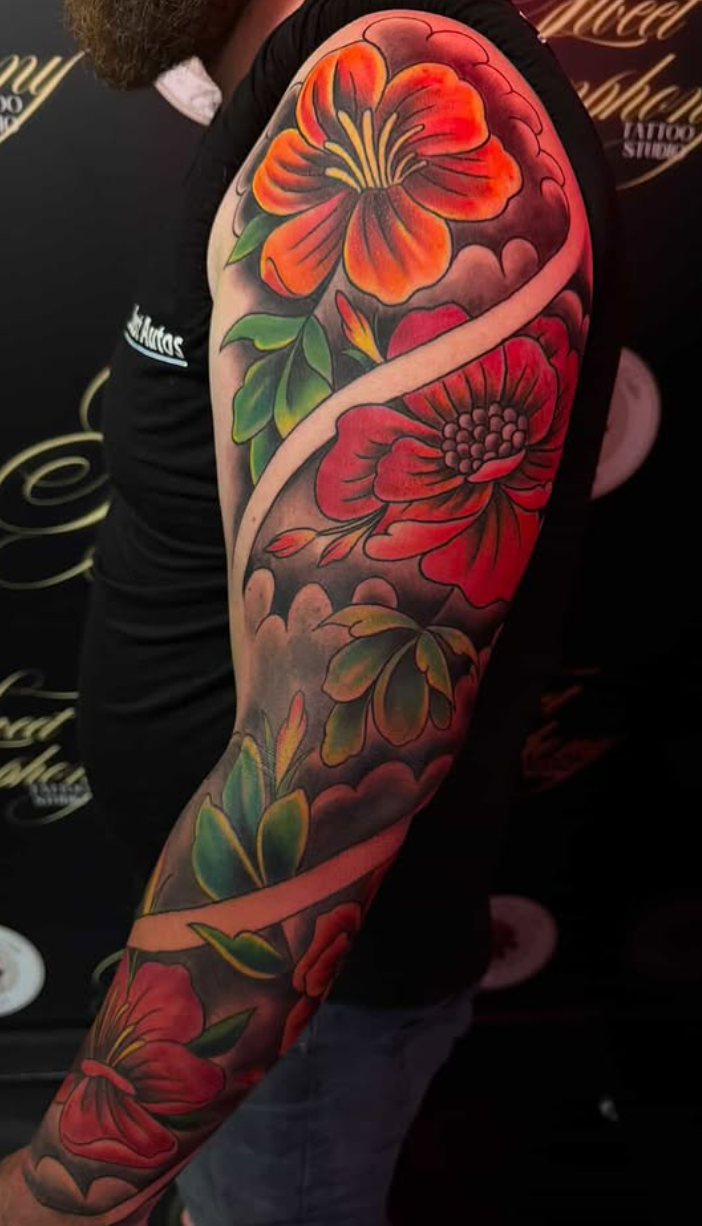 Bold traditional-style colour floral sleeve with red and orange blooms.