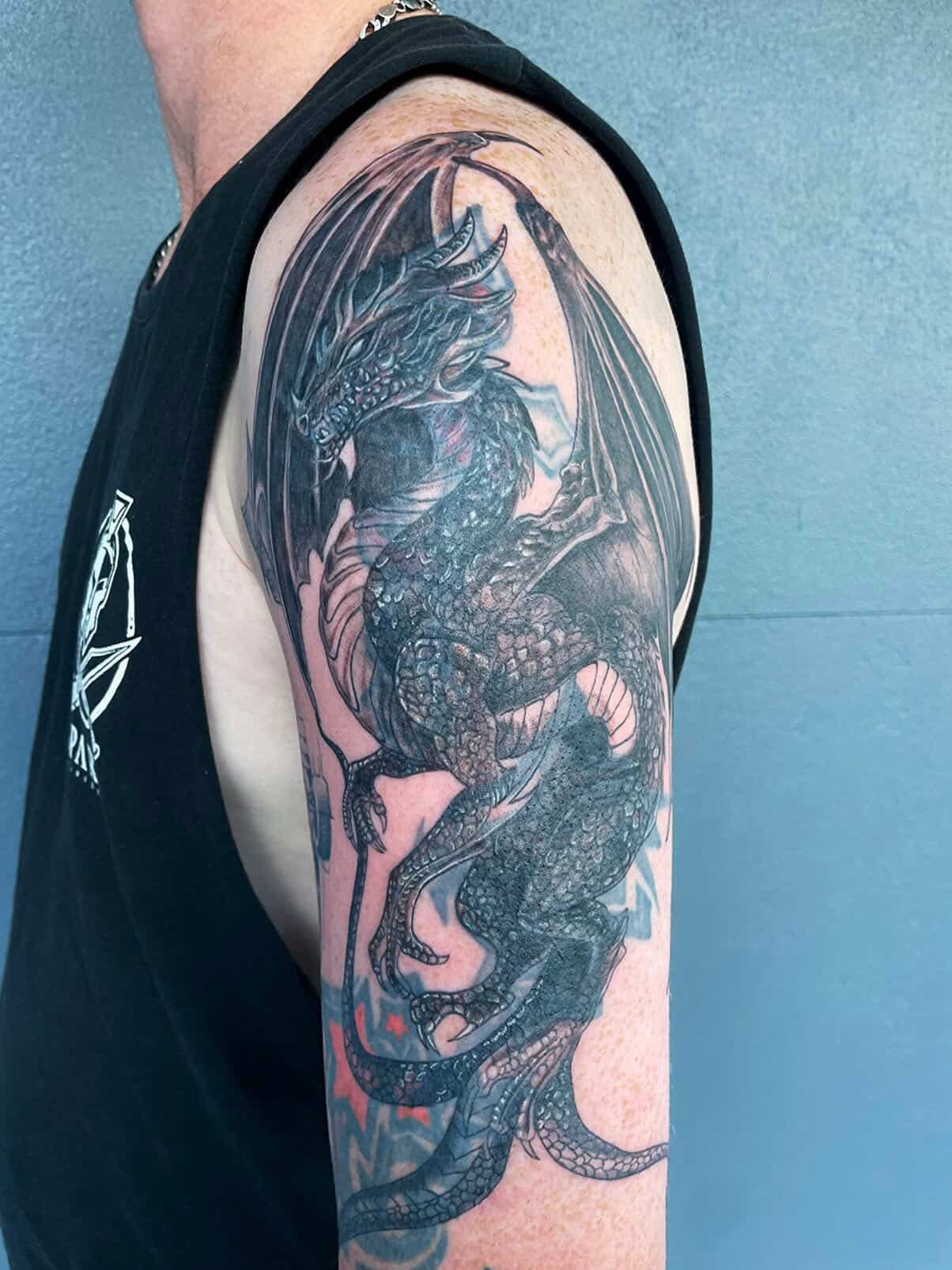 Black and grey dragon sleeve tattoo from Sweet Symphony Tattoo Instagram