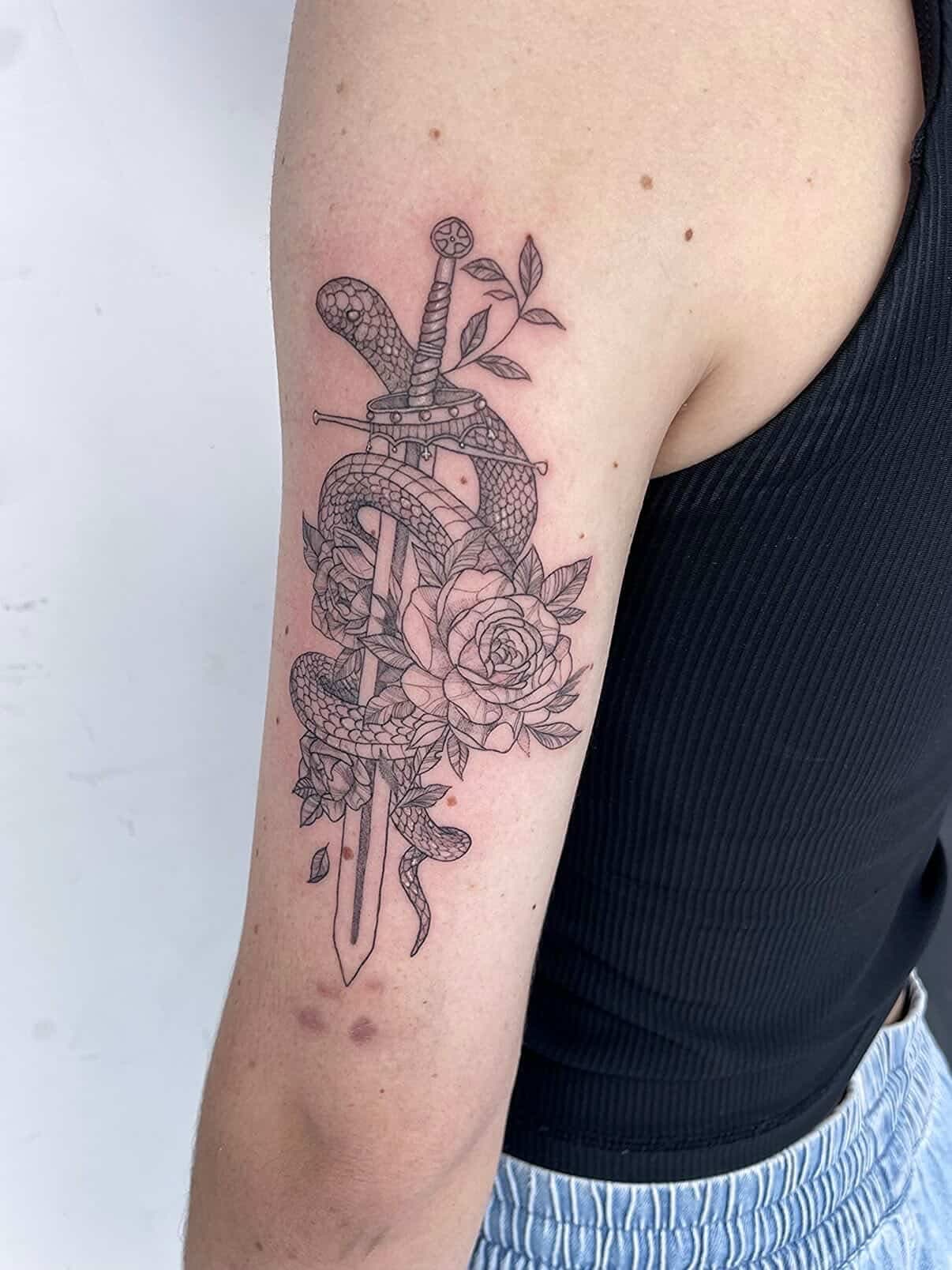 Fine-line snake wrapped around a dagger with roses on the upper arm.