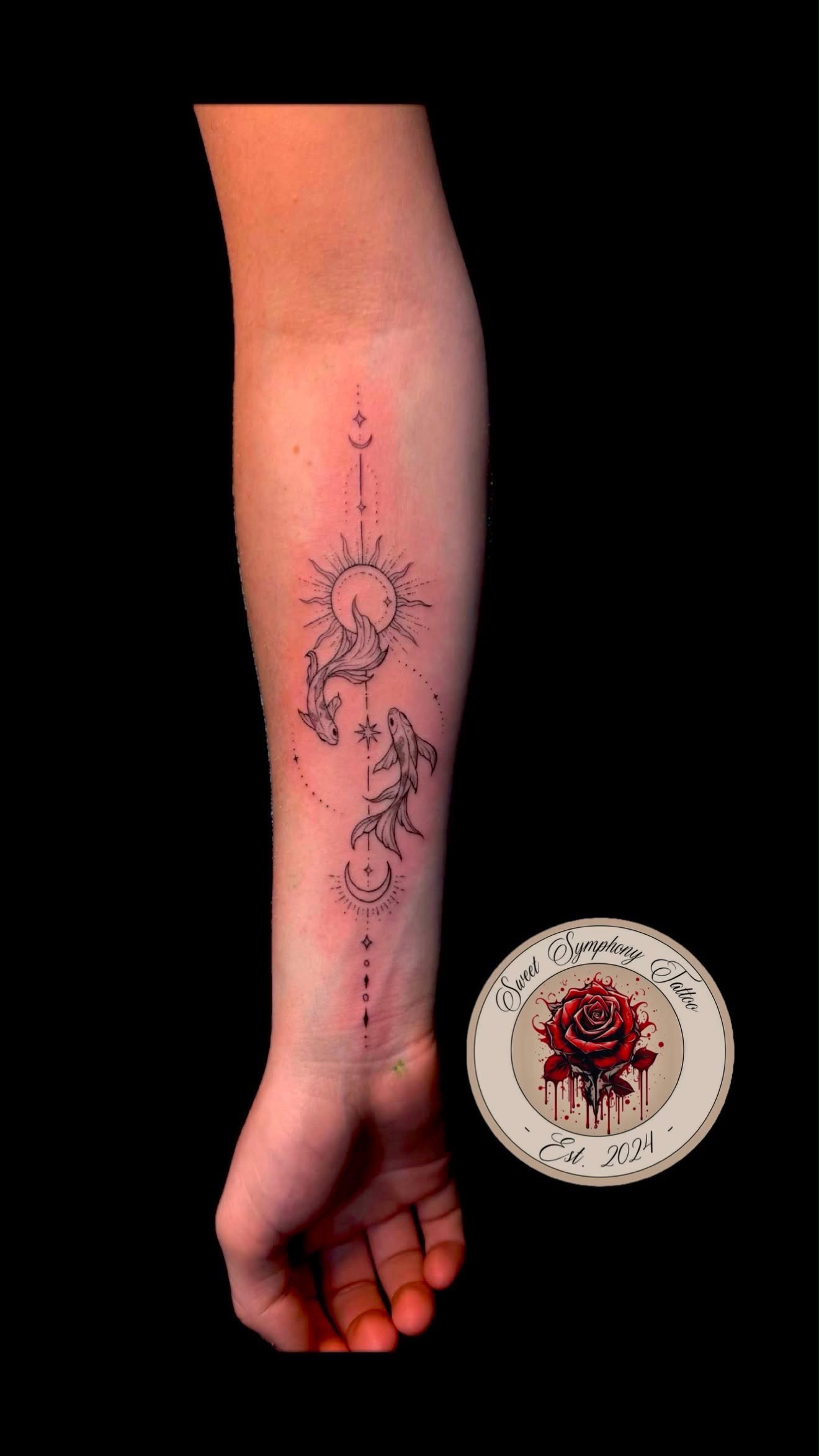 Fine-line celestial sun and moon tattoo with koi fish running down the forearm.