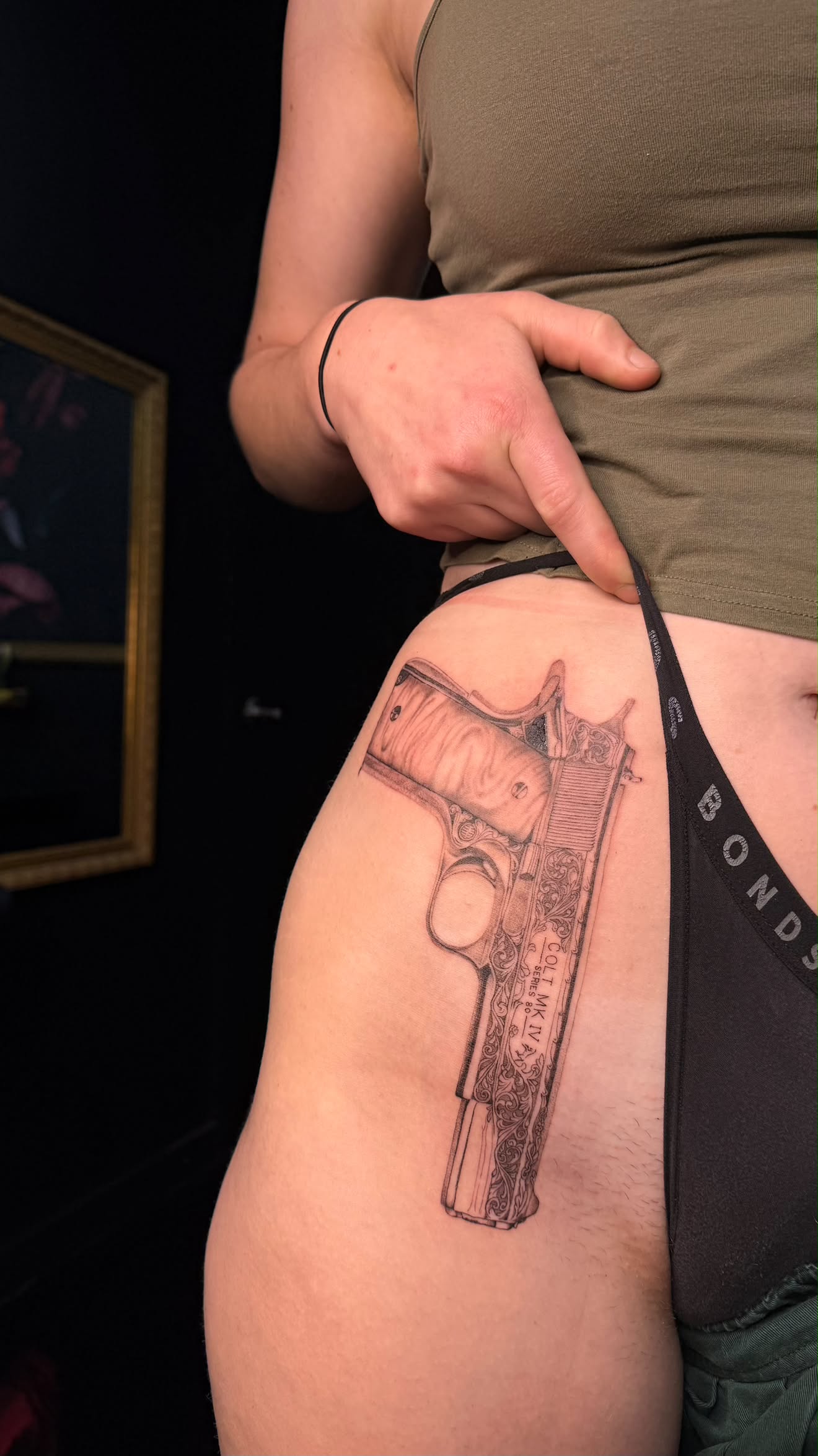 Fine-line cockatoo tattoo holding a ginger beer bottle on the forearm.