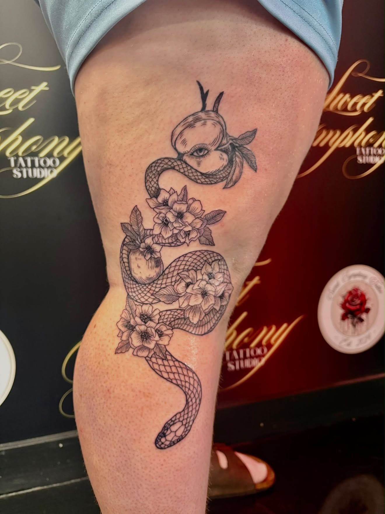 Minimalist fine-line celestial compass and flower tattoo running down the forearm.