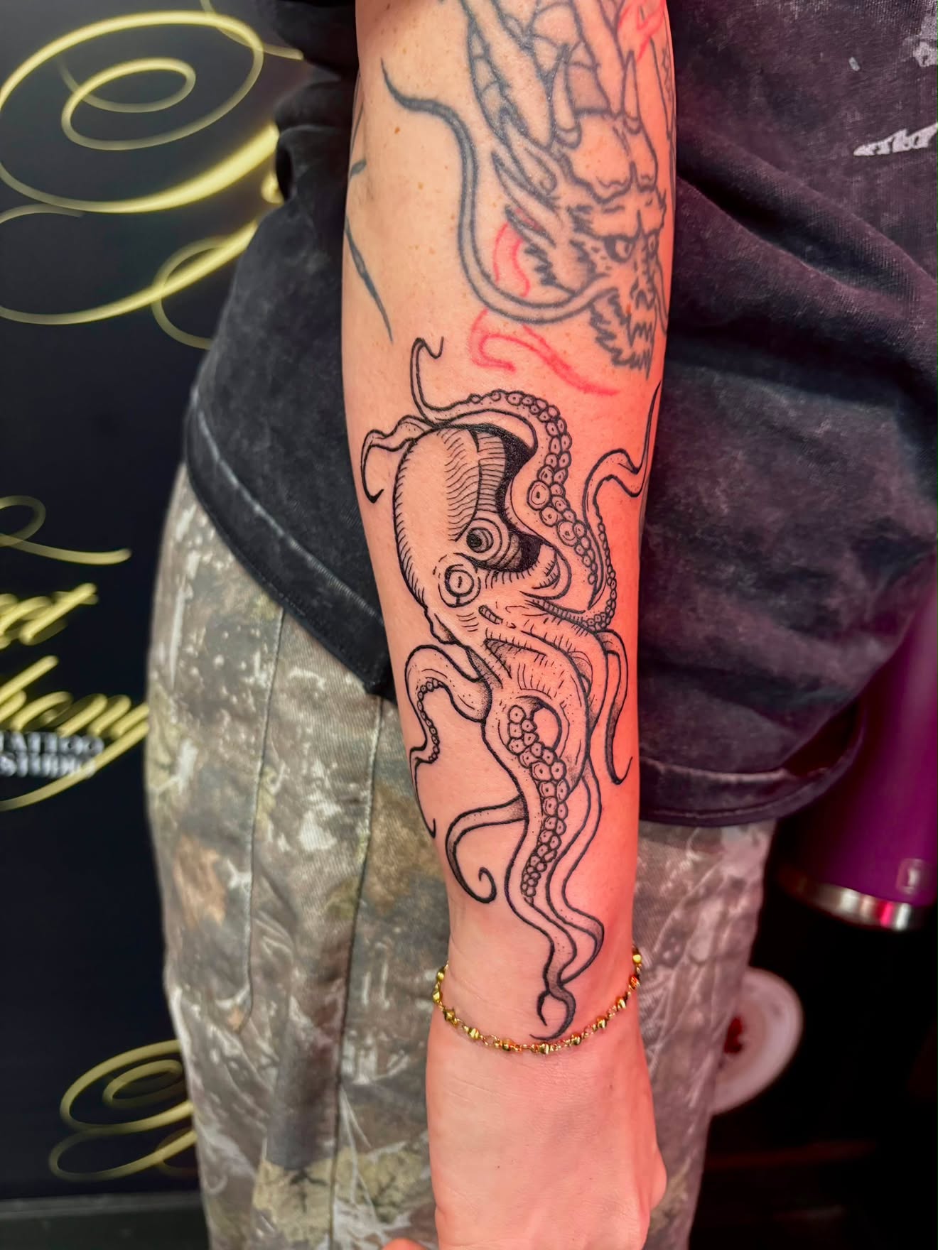 Bold blackwork octopus tattoo with dotwork shading on the forearm.